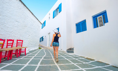 Girl in white hat walking on a greek street