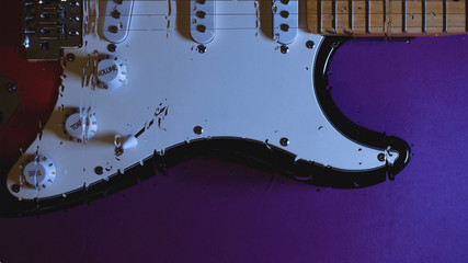 electric guitar behind the glass with water drops . color background