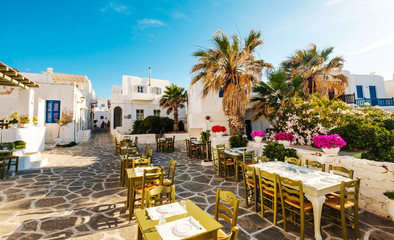 Fototapeta na wymiar Beautiful view of restaurant and white architecture around on the sunshine greek street