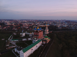 Fototapeta premium Ryazan Kremlin from a bird's-eye view at sunset. Temple with a Golden cross from a height.