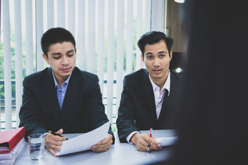 two businessman listening to candidate answers explaining about her profile, job interview concept