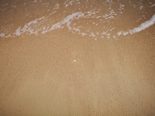 Beautiful splashing swash silky smooth water on the beach during sunny day.