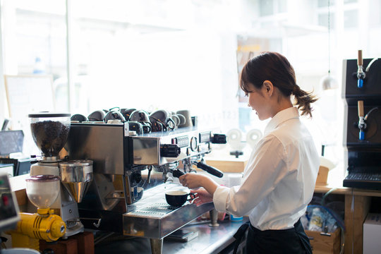 コーヒーを作る20代カフェ店員