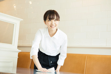テーブルを拭く20代カフェ店員