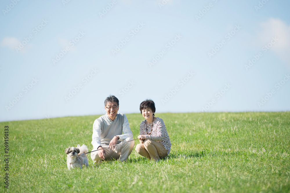 Poster 草原で微笑むシニア夫婦と犬