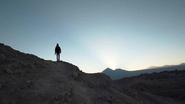 Hiker silhouette slow motion walking in the desert