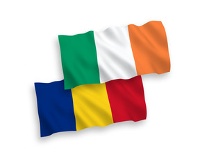 National vector fabric wave flags of Ireland and Romania isolated on white background. 1 to 2 proportion.