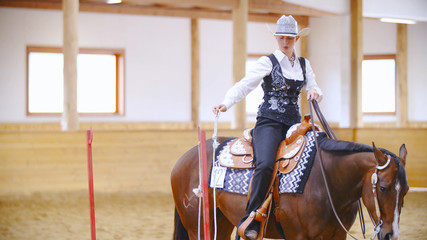 Elegant cowgirl on horse training opening the rope door