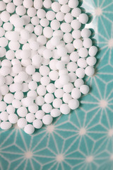 Globuli Kügelchen Detail auf blauen Hintergrun, Homöopathie Gesundheit