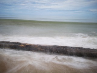 Beautiful splashing swash silky smooth water on the beach during sunny day.