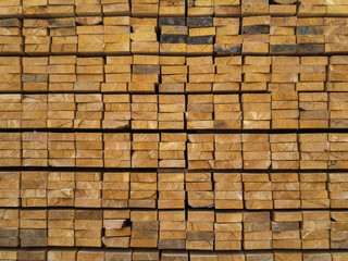 Lots of planks stacked on top of each other in the warehouse. Lumber for further use in construction