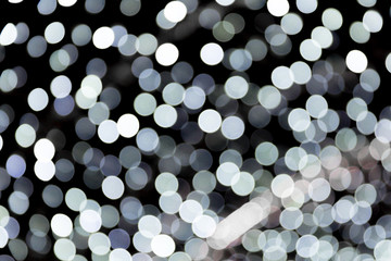 Abstract bokeh of white city lights on black background. defocused and blurred many round light