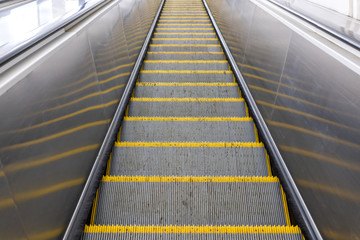 escalator steps with yellow stripes view down