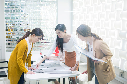 服の採寸をする20代女性3人