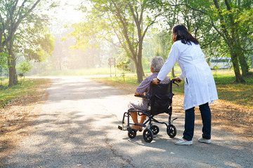 Doctor help and care Asian senior or elderly old lady woman patient sitting on wheelchair at nursing hospital ward : healthy strong medical concept 