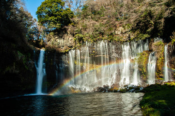 糸のような水の流れのある滝と美しい虹