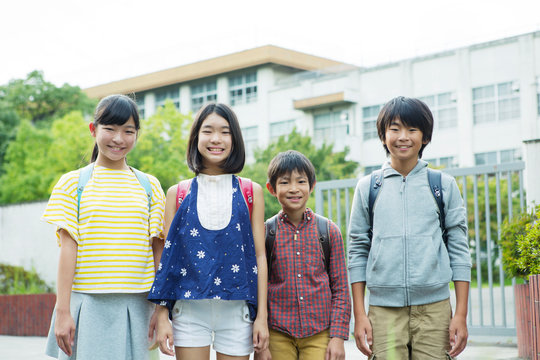 校門の前に立つ小学生男女
