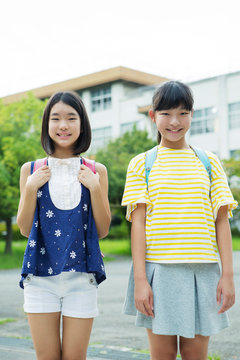校門の前に立つ小学生女子2人