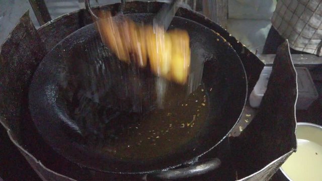 Close-up frying of Pakora, or pakoda, pakodi, fakkura, bhajiya, bhajji, bhaji or ponako, a fried snack fritters made with gram flour, of Indian subcontinent. slow motion Handheld stabilized gimbal 4k
