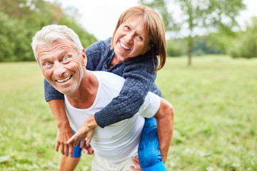 Senior Mann trägt seine Frau Huckepack