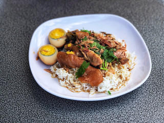 Stewed pork leg with Eggs on rice in white dish, delicious of  Thai food , Name of this menu in Thailand : 