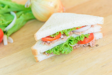 Sandwich tuna with the ingredients on wood plate