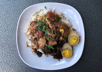 Stewed pork leg with Eggs on rice in white dish, delicious of  Thai food , Name of this menu in Thailand : 