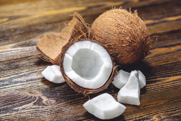 Open coconut with white pulp on wooden background. Organic healthy vegan product widely used in...