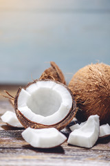 Open coconut with white pulp on wooden background. Organic healthy vegan product widely used in cosmetics