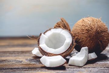 Open coconut with white pulp on wooden background. Organic healthy vegan product widely used in cosmetics