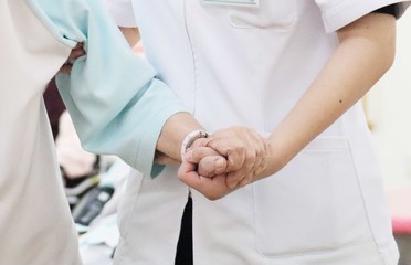 シニア女性を支える介護士の優しい手