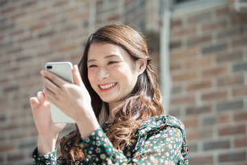 スマホを持つ笑顔の20代女性