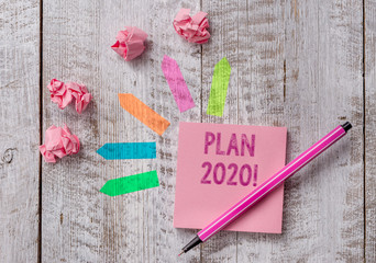 Conceptual hand writing showing Plan 2020. Concept meaning detailed proposal doing achieving something next year Note paper and line arrow stickers on the top of wooden table desk