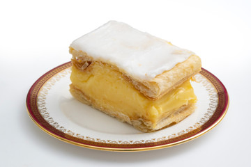 Vanilla slice, a popular cake in the UK and Europe on a plate, made of confectioners custard, flaky pastry and icing