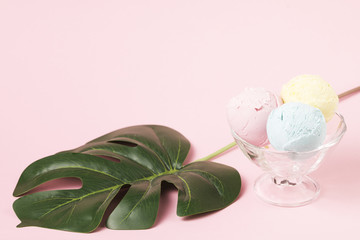Ice cream balls on glass bowl near monstera leaf