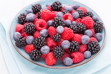 Fresh raspberries in a plate on a  vintage background.