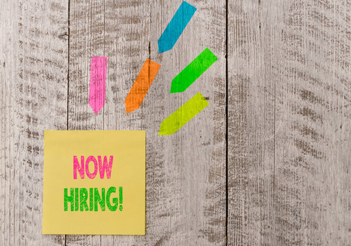 Conceptual hand writing showing Now Hiring. Concept meaning finding evaluating working relationship with future employees Note paper and line arrow stickers on the top of wooden table desk
