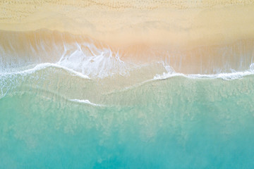 Fototapeta na wymiar Aerial view of turquoise ocean wave reaching the coastline. Beautiful tropical beach from top view. Andaman sea in Thailand. Summer holiday vacation concept