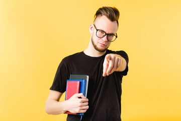 Personal motivation. Successful career. Portrait of confident millennial guy holding notebooks, pointing finger at you.