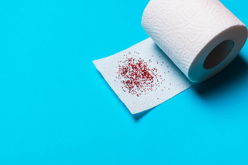 Hemorrhoids treatment concept, toilet paper on a blue background