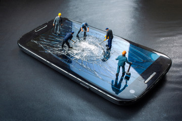 workers work on the broken screen of a mobile phone