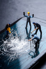 workers work on the broken screen of a mobile phone