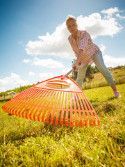 Unusual angle of woman raking leaves