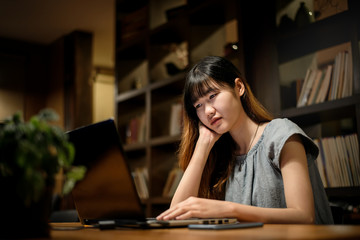 Happy Beautiful Asian Student woman working on  laptop in  modern library  room