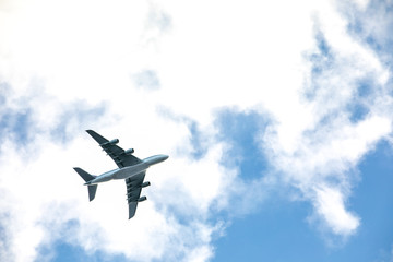  Airplane flies over the city, blue and cloudy sky