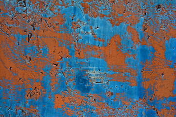 Textures and background of old metal sheet. Peeling paint on blue and brown sheet metal background. Minor scratches and damage.