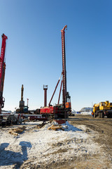 Drilling equipment, excavators, trucks build the sea port of Sabetta. Yamal, Russia. Winter, sunny