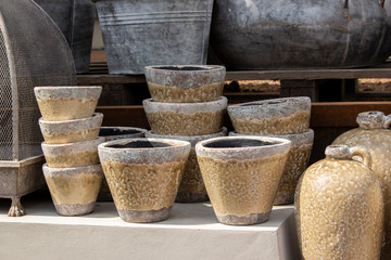 Clay flower pots in the window of a gardening shop. Brown glazed pots for room flowers and interior decor