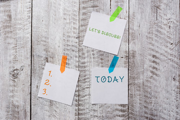 Conceptual hand writing showing Let S Discuss. Concept meaning asking someone to talk about something with demonstrating or showing Plentiful of plain paper sheet attached with wooden textured table