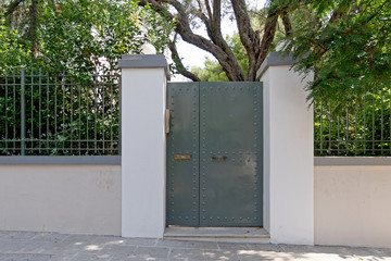 house entrance metalic gray door on white fence